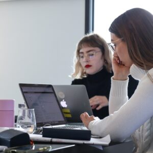 Två tjejer sitter med laptops och programmerar